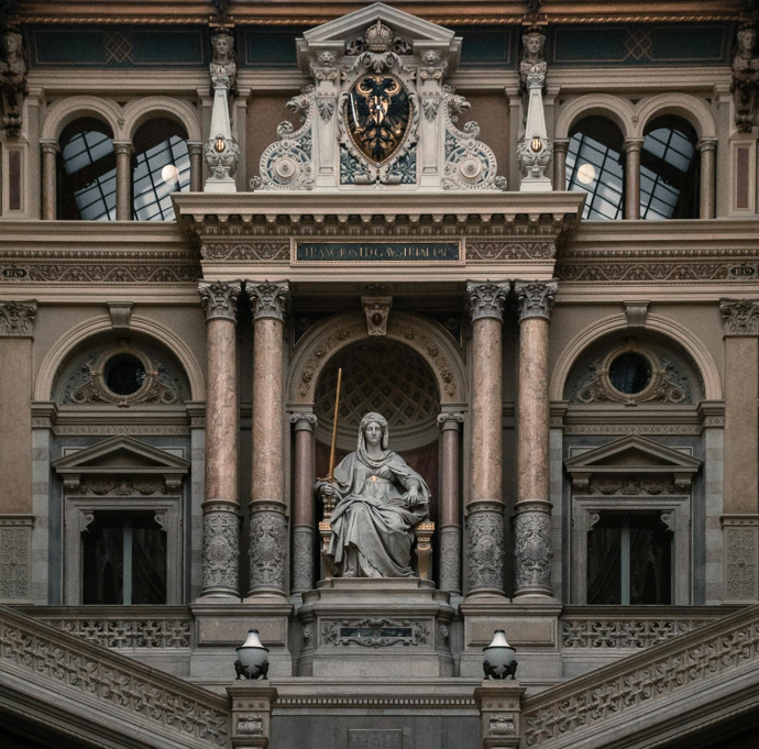 Eine Statue von Justitia, Göttin der Gerechtigkeit, thront über einer Treppe im Wiener Justizpalast, Sitz des Obersten Gerichtshofs.